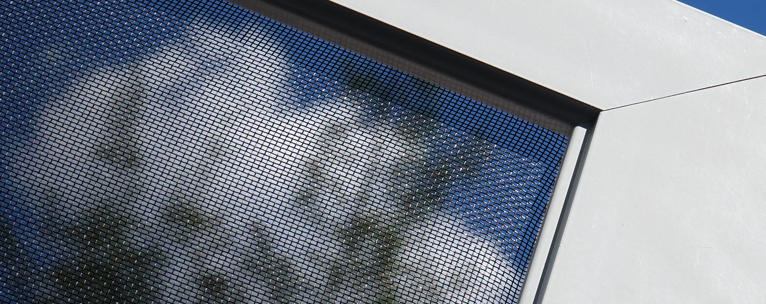 Close-up of window screen mesh against the sky